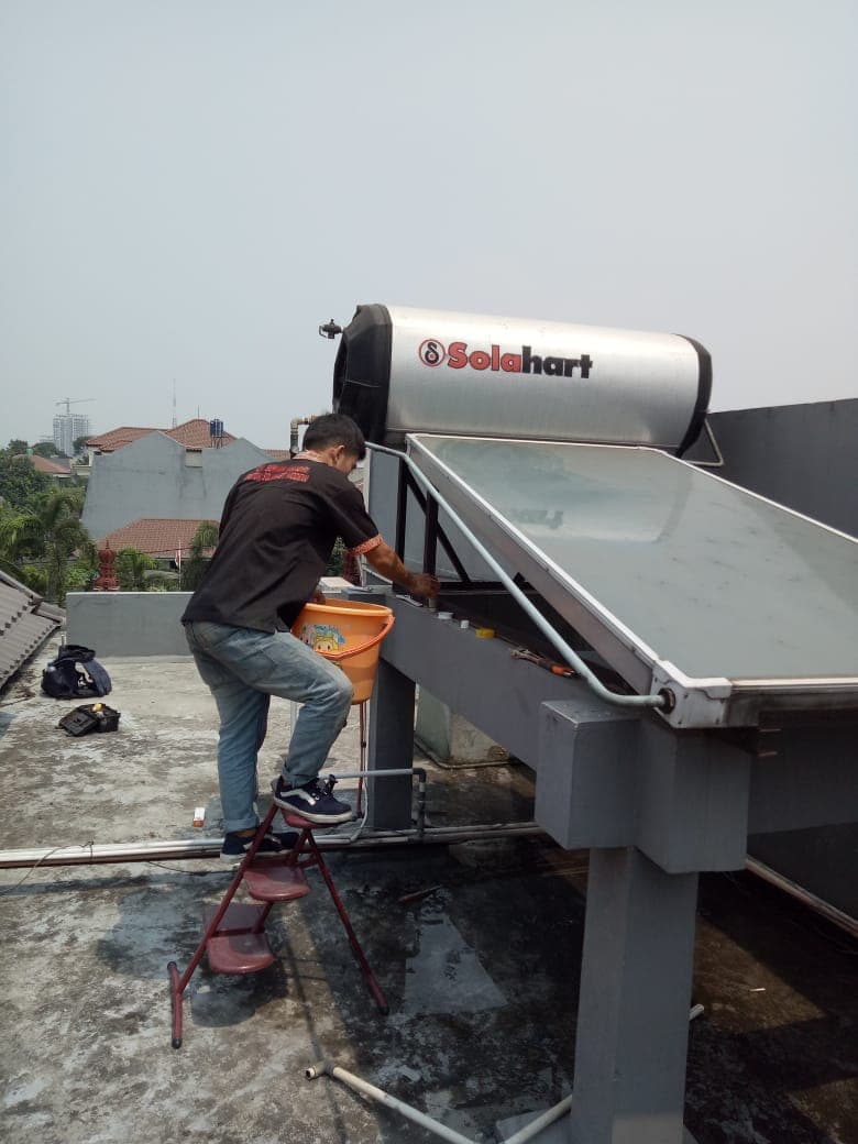 Teknisi membersihkan Water Heater Solahart di rooftop
